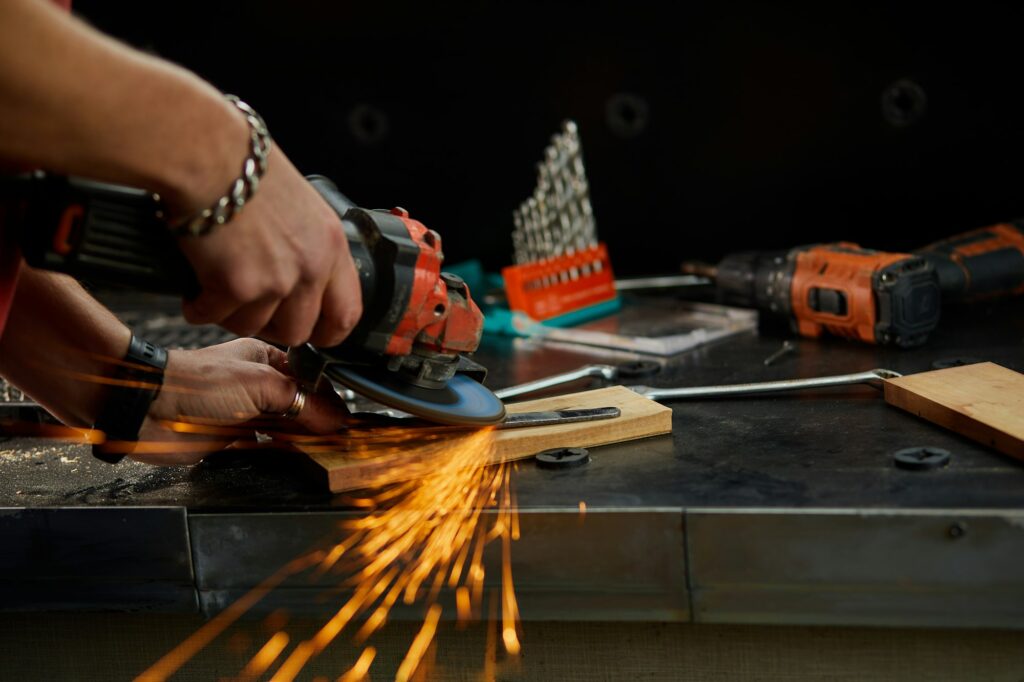 Close up Locksmith works with grinder machine, fly bright sparks.