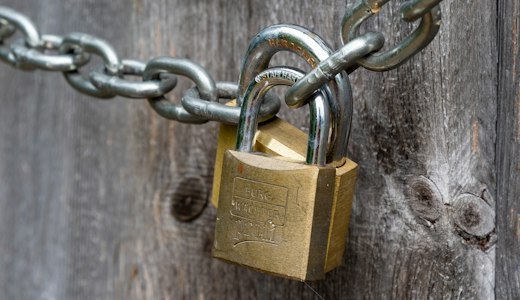 Brown padlock on brown wooden fence