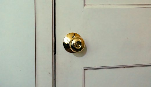 Close up of a door handle on a white door