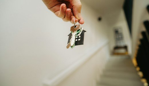 Person holding a house key in their hand
