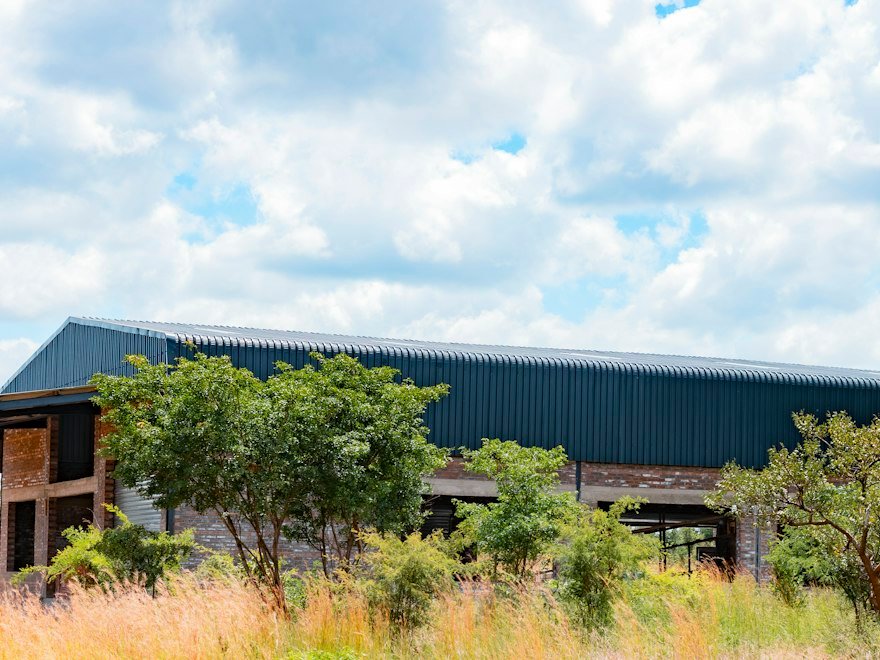 Long industrial building with a dark metal roof